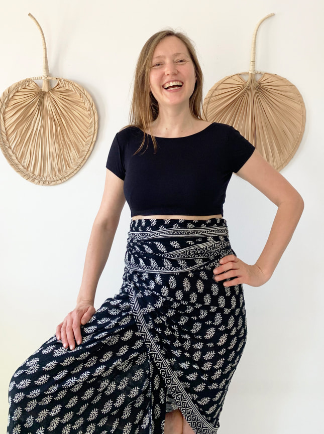 The ByGungur Pearl Crop is a reversable multi use crop top which can be worn in differnt ways. Here the model's wearing the crop top with the high round neckline at the fron and the deep V cutaway at the back. She's wearing the crop top with the ByGungur block print wrap worn as a high waisted wrap around skirt.