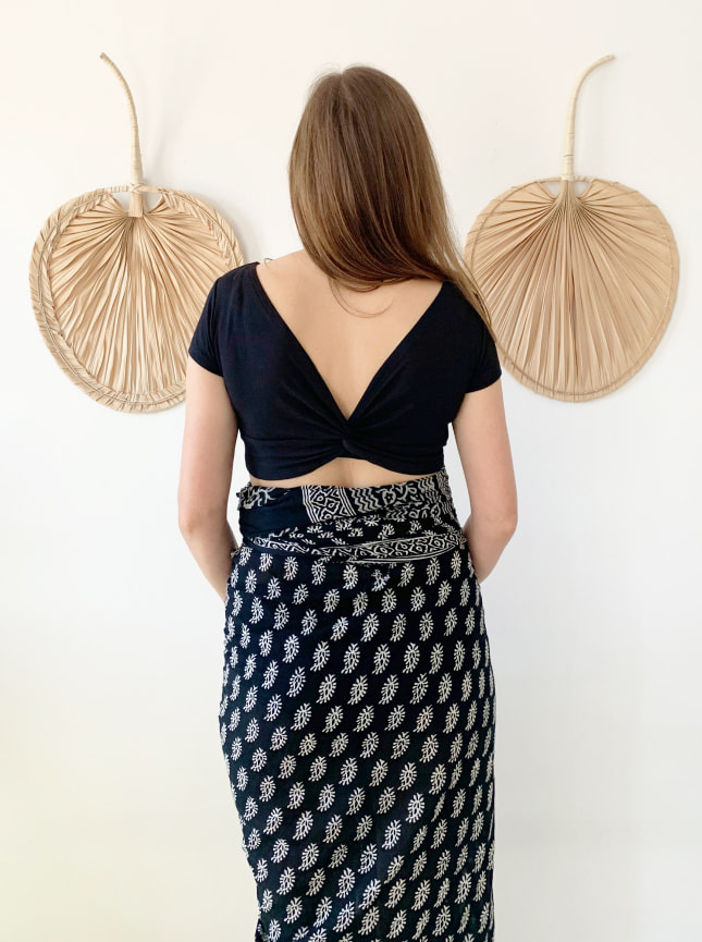 The ByGungur Pearl Crop is a multiuse crop top that can be worn various ways. Here the model wears it as a V back crop top with the high round neckline at the front. She is wearing the black Pearl Crop with the ByGungur block print wrap skirt.