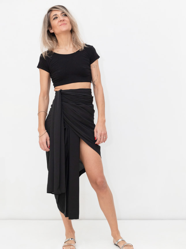 ByGungur Black Wrap skirt gives a stunning asymetric skirt, longer at one side than the other. The model is wearing the wrap skirt with the Pearl Crop top, a reversable multi use belly top.