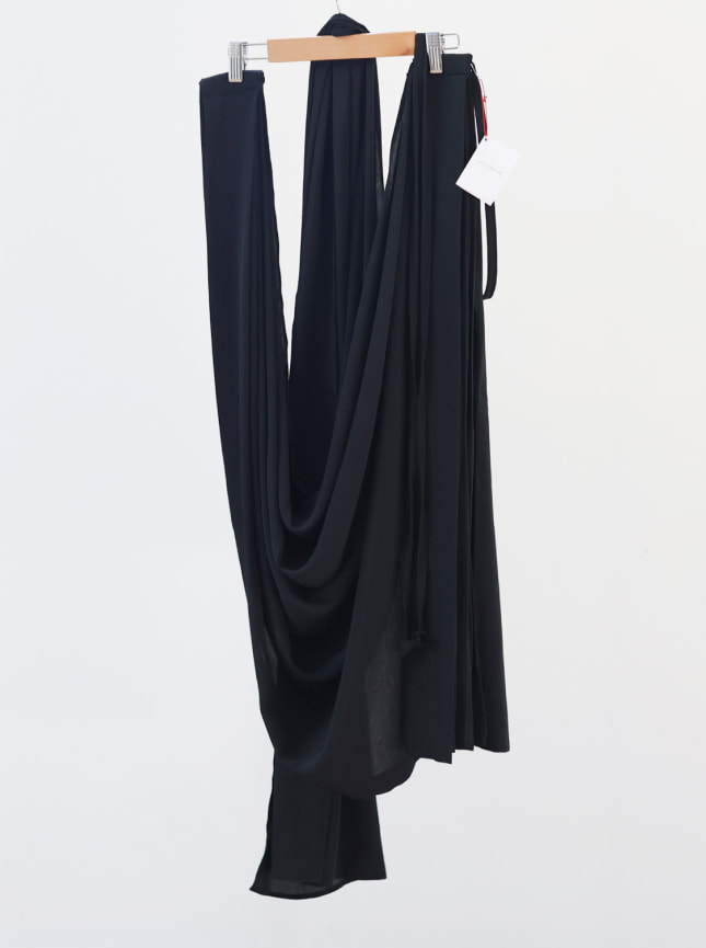 ByGungur wrap dress black on stored on hanger. The ByGungur convertible wrap is a versatile wraparound dress and skirt in one. As a dress it can be worn as a one shoulder wrap dress, a strapless boob tube dress, a halter dress, a cross over top and skirt, or a skirt.