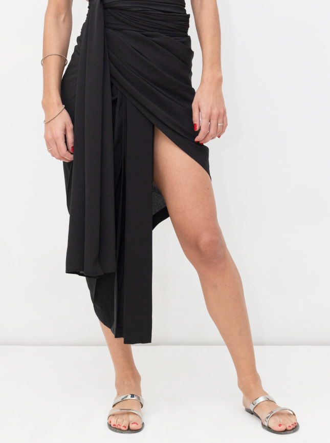 The ByGungur wrap dress in black. Here it's worn as an asyemetric wrap around skirt. The skirt is wrapped around the waist and tied at the side.