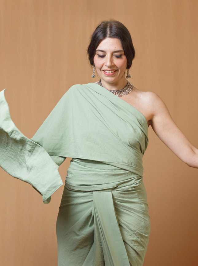 The ByGungur multi use wraparound dress in green is worn here in the saree style. This one shoulder style wraparound dress is sexy and elegant. The draped material on the torso can be pinned at the shoulder or at the back or left to hang free for a fun and playful look. The bottom part of the dress is wrapped as asymetric skirt and tied at the back or at the side.