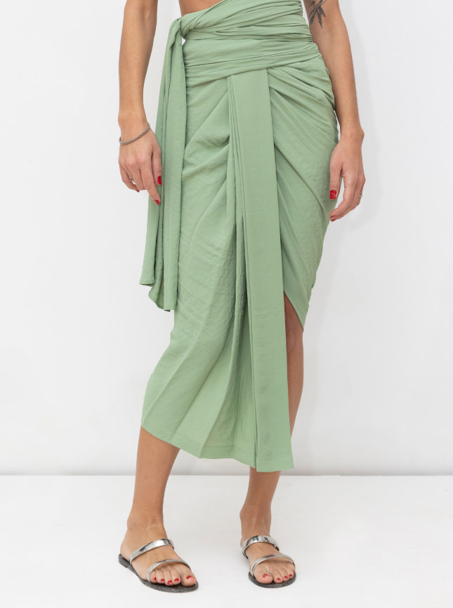 The ByGungur multi use wrap dress in green is worn here as a wraparound skirt. It's wrapped around the waist to give a multilength skirt and tied at the side. It can be worn on the hips or high waisted.
