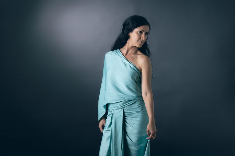 The ByGungur Wrap Dress is a multi use evening wrap dress in Esmerald light blue. Here it's worn as a saree style dress, wrapped around the waist with a central pleat and draped over the left shoulder.