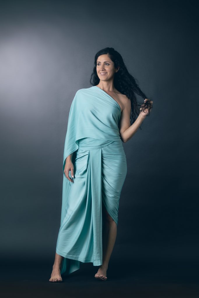 The ByGungur Wrap Dress worn as the saree style dress in enchanting light blue Esmerald colour. An asymetric maxi wrap dress it wraps arorund the waist and is draped or pinned over the left shoulder.