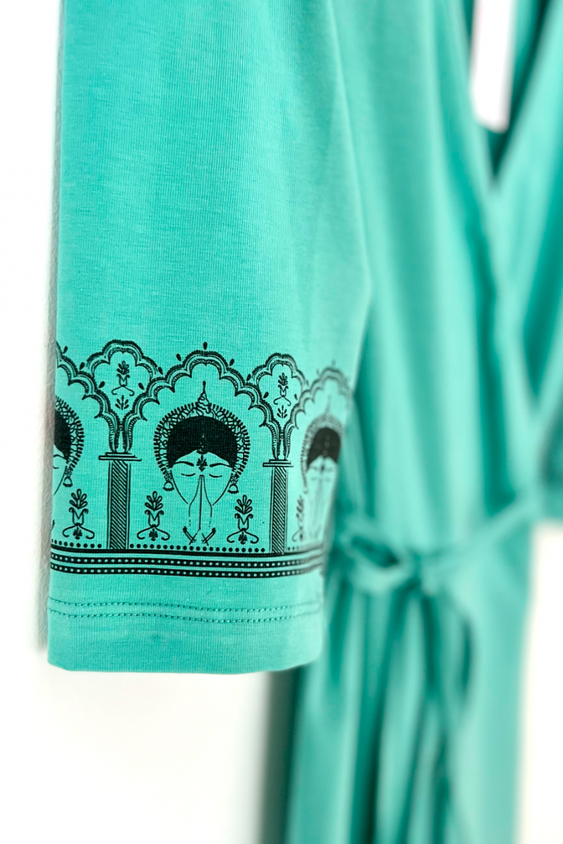 A close up image of the ByGungur Lotus Kurta Light Blue sleeve design. Three quarter length sleeves are decorated with the Gungur signature design, an Odissi dancer with hands in Anjali mudra edged with a motif inspired by the temples in the state of Orissa, India.
