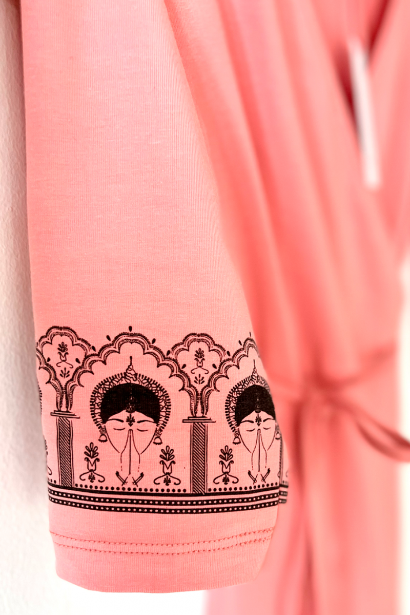 The ByGungur Lotus Kurta Rose features three quarter sleeves which are decorated with a unique design. The design features athe face of an Odissi dancer with hands in Anjali mudra. The border around the dancer is inspired by the temples of Orissa in India.