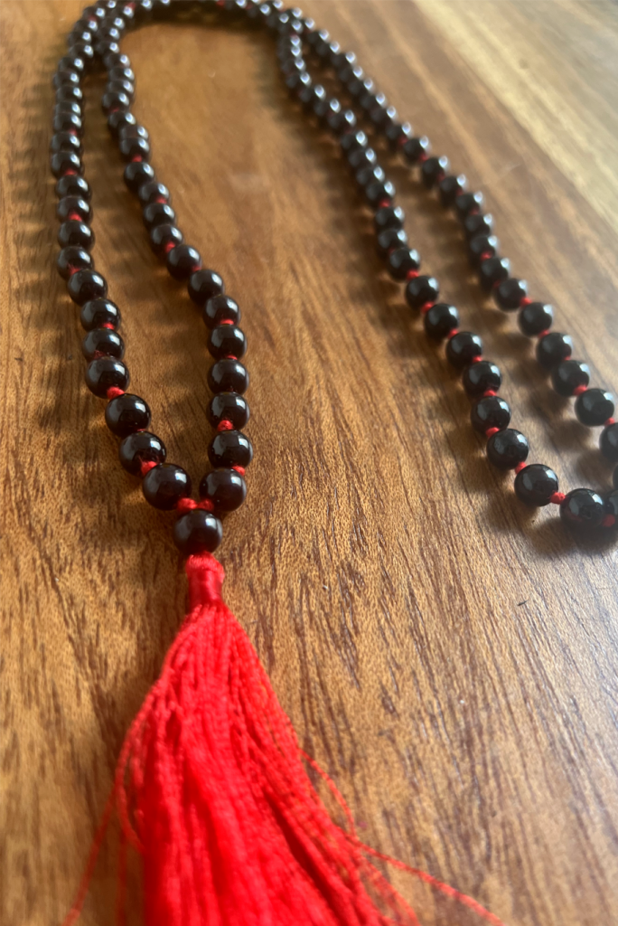 ByGungur Garnet Mala beads. 108 genuine semi precious garnet stones are threaded by hand on cototn thread to make these beautiful prayer beads. Each stone is round and highly polished which feels beautiful to touch and to look at
