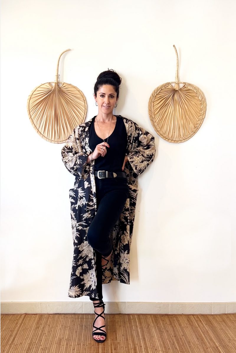 This floral print kimono is made of 100% cotton. In black and white it's versatile and can be dressed up or down. Here the model is wearing it with black jeans and a black top for a distinctive smart casual look.